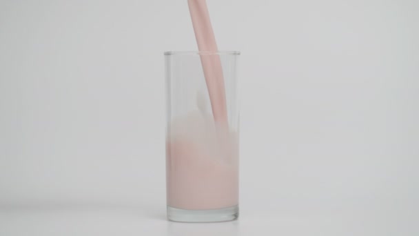 Mouvement lent de verser le lait dans le verre à 1000fps, fond bleu — Video