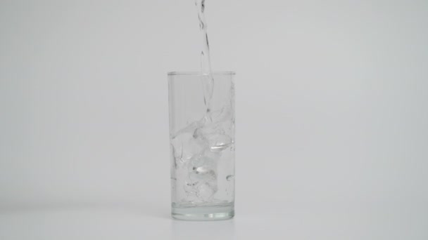 Movimiento lento de verter agua en vidrio, 1000 fps en fondo blanco — Vídeos de Stock