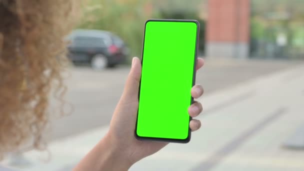 Afrikaanse vrouw op zoek naar smartphone met groene chroma scherm — Stockvideo
