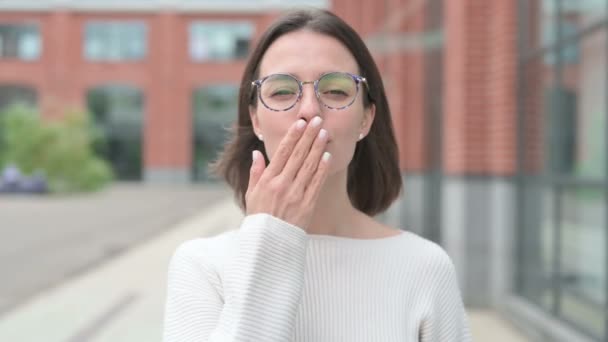 Joven mujer dando un beso volador, de pie al aire libre — Vídeos de Stock