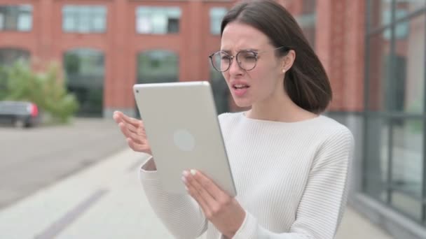 Mladá žena s ztrátou na tabletu při chůzi po ulici — Stock video