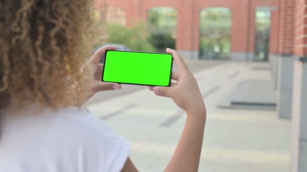 Mujer africana mirando Smartphone con pantalla de croma verde — Vídeos de Stock