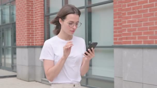 Jovem Mulher Navegando na Internet no Smartphone enquanto Caminhando na Rua — Vídeo de Stock