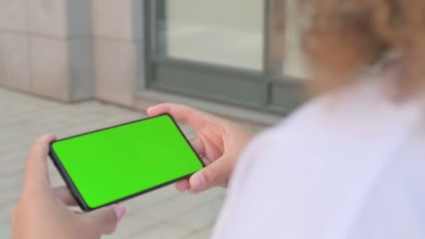 用绿色彩色屏幕看智能手机的非洲妇女 — 图库视频影像