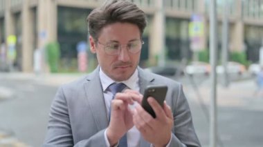 Akıllı Telefonda İnternet'e Göz Gezen Orta Yaşlı İşadamı