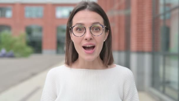 Mujer joven emocionada celebrando el éxito, al aire libre — Vídeos de Stock