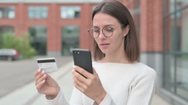 Молодая женщина, имеющая успех онлайн оплаты на смартфоне — стоковое видео