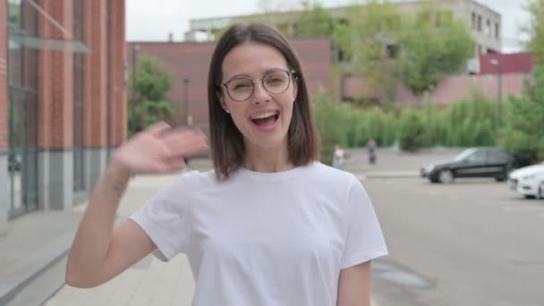 若い女性が路上で歩いている間にオンラインビデオ通話で話す — ストック動画