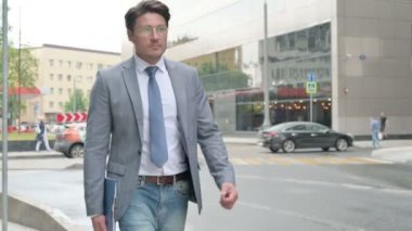 Elinde Dosya Tutarken Sokakta Yürüyen Orta Yaşlı İşadamı 