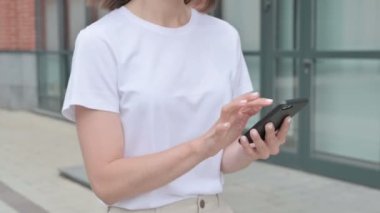 Smartphone 'da internette gezinen kadın sokakta yürürken