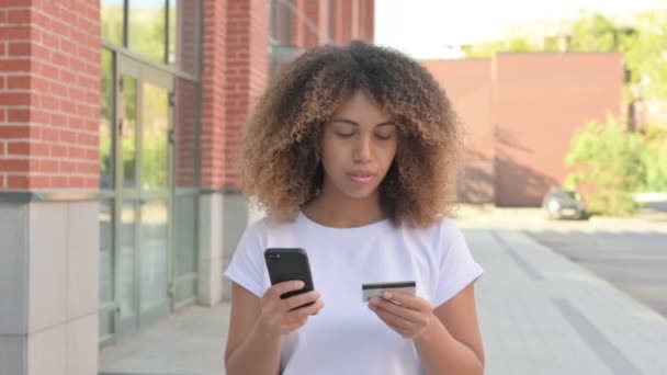 スマートフォンでオンライン決済に失敗したアフリカの女性を歩く — ストック動画