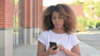 Genç Afrikalı Kadın Smartphone 'da internette geziniyor.