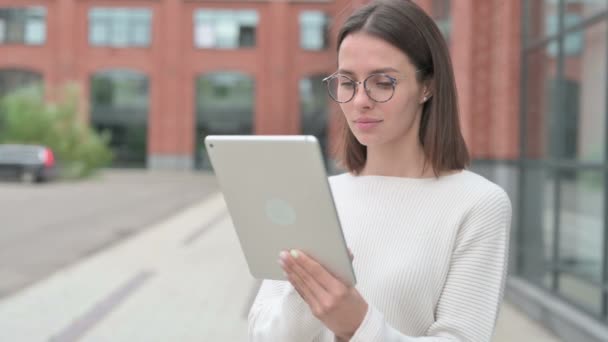 Mujer joven navegando por Internet en la tableta mientras camina por la calle — Vídeos de Stock