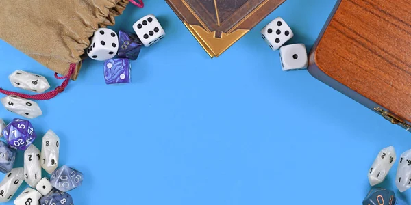 Banner with tabletop role playing items like blue and white RPG dices, character sheet and rule books with empty copy space on blue background in middle