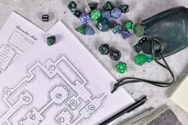 Masaüstü rolü düz oynanır RPG oyun zarları, karakter tablosu, zindan haritası ve tahta masa üzerinde kalem ile yatar