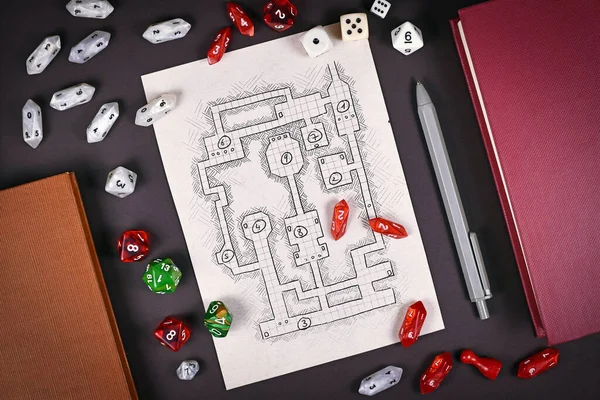 Tabletop role playing flat lay with RPG game dices, hand drawn dungeon map, rule books and pen on dark background
