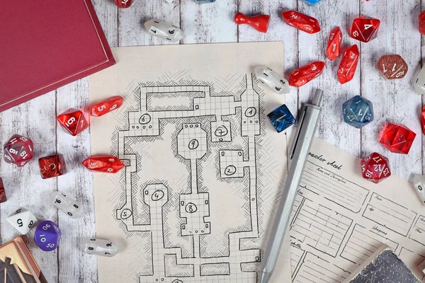 Tabletop role playing flat lay with RPG game dices, hand drawn character sheet, dungeon map and pen on wooden desk