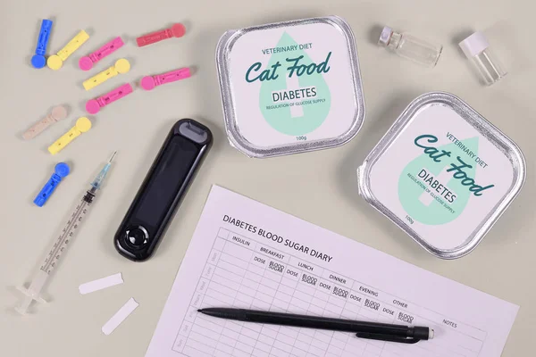 Concept for Diabetes disease with cats with veterinary cat food, glucometer and syringe and blood sugar diary