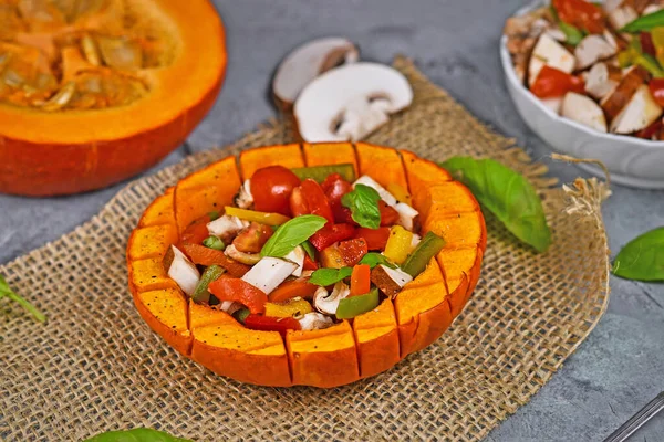 Vegan baked Red kuri squash vegetable filled with bell pepper, tomatoes and mushrooms surrounded by ingredients
