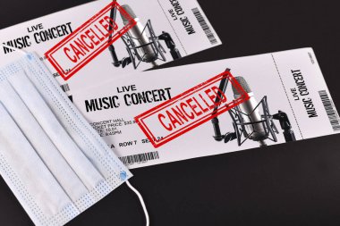 Corona virüs salgını sırasında iptal edilen konser biletleri ve kırmızı 'iptal edildi' damgası konsepti ve yüz maskesi