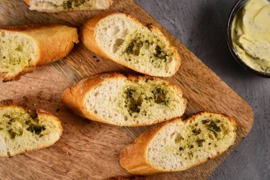 Tahta kesme tahtasının üzerinde erimiş bitki yağı ile kaplı ekmek dilimlerinin üst görüntüsü