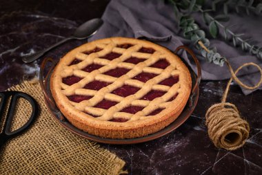 'Linzer Turta' adlı ev yapımı turta, üzerinde meyve reçelleri ve kafes tasarımlı dilimlenmiş fındıklı geleneksel Avusturya pastası. 