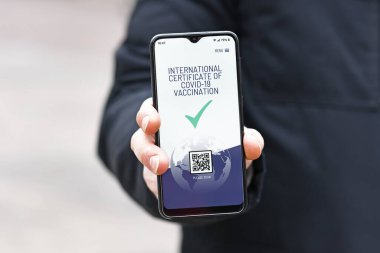Uluslararası Corona virüsü aşı pasaportu için cep telefonu aygıtındaki kavram aşılı insanlara ayrıcalık tanıyor