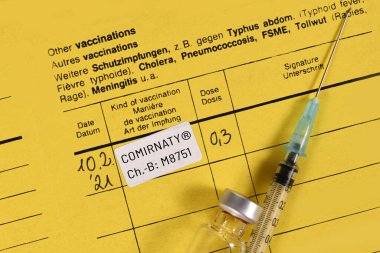 Dossenheim, Almanya - Şubat 2020: PfizerBioNTech COVID-19 aşı aşılama sertifikası Şırınga ve şişe