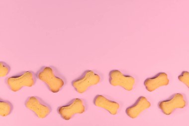 Pembe arkaplandaki kemik şekilli köpek bisküvileri boş kopya alanı ile
