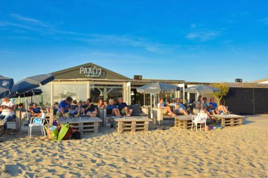 Texel, Hollanda - Ağustos 2019: Kuzey Hollanda 'daki Texel Adası' ndaki 'Paal 17' adlı plaj salonunda dinlenen turistler