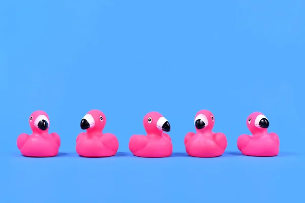 Rosa Gummiente Flamingos Einer Reihe Auf Blauem Hintergrund Mit Kopierraum — Stockfoto