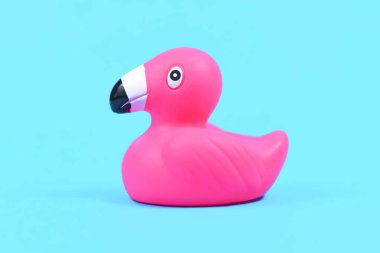 Mavi arka planda tek pembe plastik ördek flamingoları 
