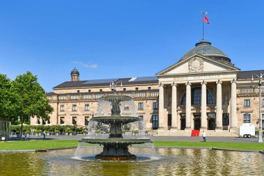 Wiesbaden, Almanya - Temmuz 2021: Kurhaus adlı kongre merkezinin önündeki 'Bowling Green' adlı halk parkındaki çeşme