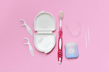 Pembe arkaplan üzerinde diş fırçası, diş fırçası, kürdan ve diş ipiyle fotokopi alanının üst görünümü