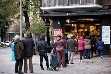 Madrid, İspanya - 7 Kasım 2020 İnsanlar covid nedeniyle sosyal uzaklık nedeniyle bir mağazada kuyruğa giriyor