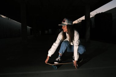 Genç bir kadın otoparkta kayıyor.