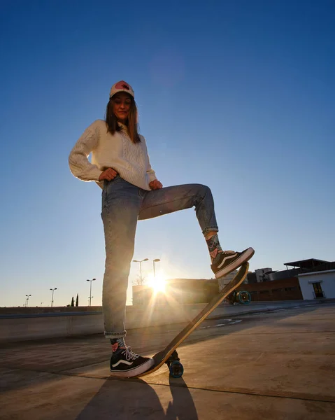 Mujer joven patinando en un techo durante el atardecer — Foto de Stock