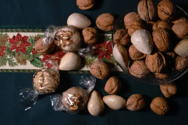 Christmas sweets with nuts and almonds over a christmas tablecloth — Stock Photo, Image