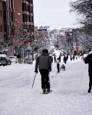 Madrid, İspanya - 9 Ocak 2021. İnsanlar tarihi bir kar yağışı sonrasında şehir merkezinde kayak yapıyorlar.