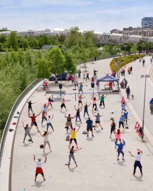 Madrid, İspanya - 15 Mayıs 2021. Madrid Rio 'da egzersiz yapan bir grup insan.