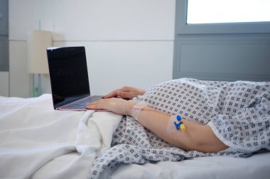 Hastanede dizüstü bilgisayarını kullanan hamile kadın.