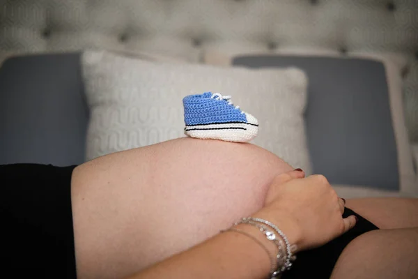Laarzen op de buik van een zwangere vrouw — Stockfoto