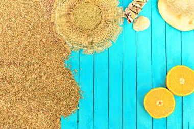 Plaj planı. Gök mavisi ahşap iskele ya da güneş panayırı olan çakıl taşlı kum. Hasır şapka, bilezik, deniz kabuğu ve sarı turuncu. Seyahat ve turizm. Boşluğu kopyala