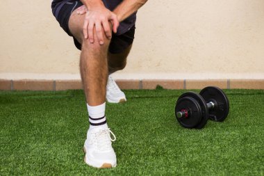 Yakışıklı sporcu, dışarıda antrenman yaparken esniyor.