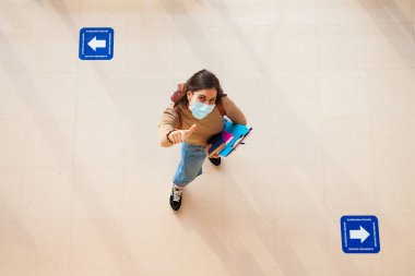 Coronavirus döneminde maske takan genç bir üniversite öğrencisi.