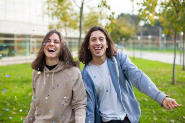 İki arkadaş dışarıda konfeti ile kutlama yapıyor.