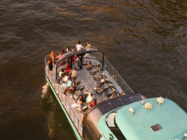 İnsanlar nehirde yüzen bir gemide dinleniyorlar. Yukarıdan görüntüle.
