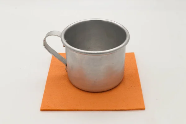Plain aluminum mug on an orange napkin — Stock Photo, Image