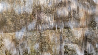 Doğal arka plan, su taştan bir duvardan aşağı akıyor.