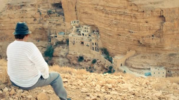 Člověk při pohledu na St. George Monastery, Izrael, poušť Stock Video
